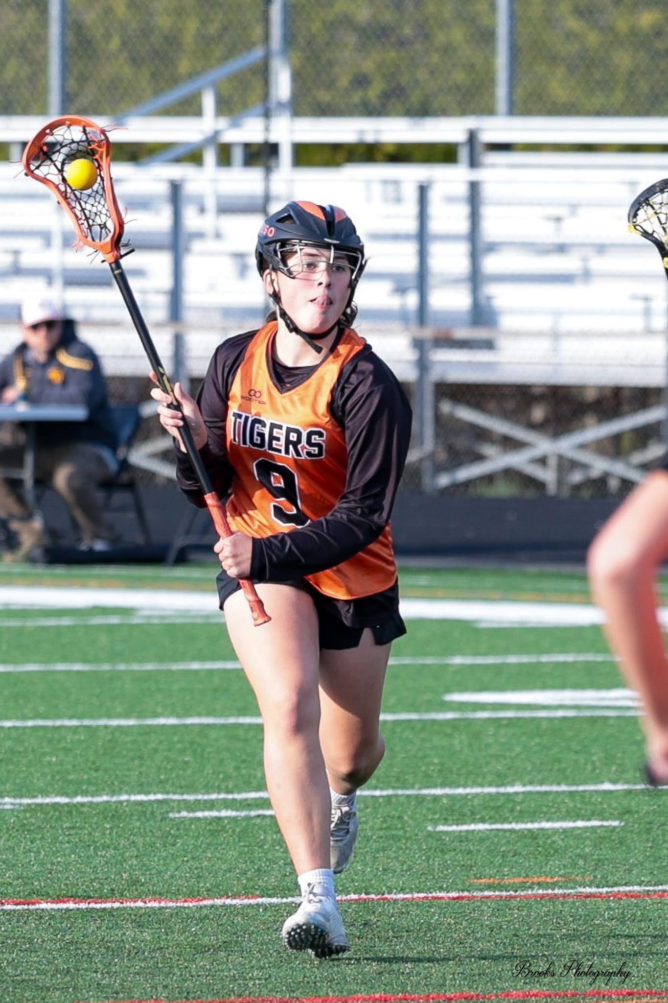 Bella Rosso carrying the ball in lacrosse game action